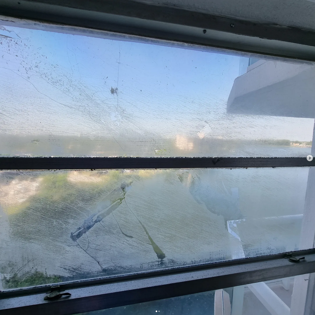 Dirty window with salt and grime buildup before cleaning