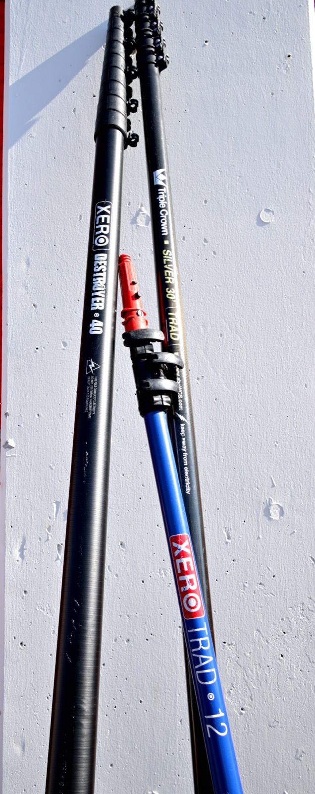 Three window cleaning extension poles used by Shiny Windows: the 40-foot Xero Destroyer water-fed pole, the Triple Crown Silver 30 traditional pole, and the Xero TRAD 12